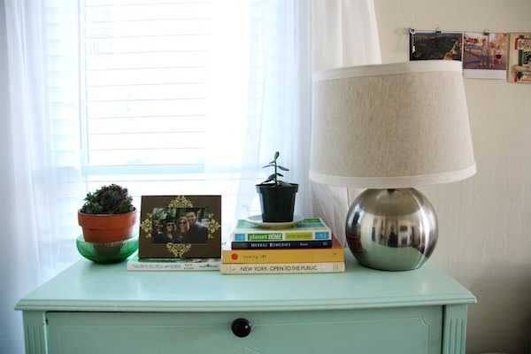 Plants and books on blue dresser.